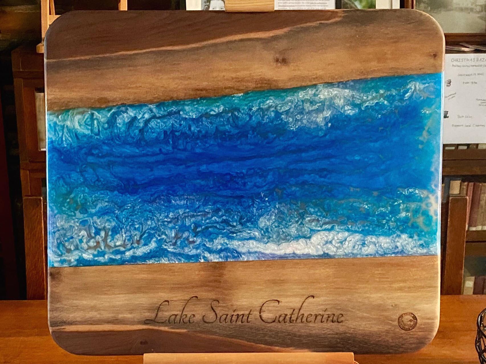 A custom-made walnut and epoxy charcuterie / cutting board engraved with Lake Saint Catherine from Swimming Dog Studios 